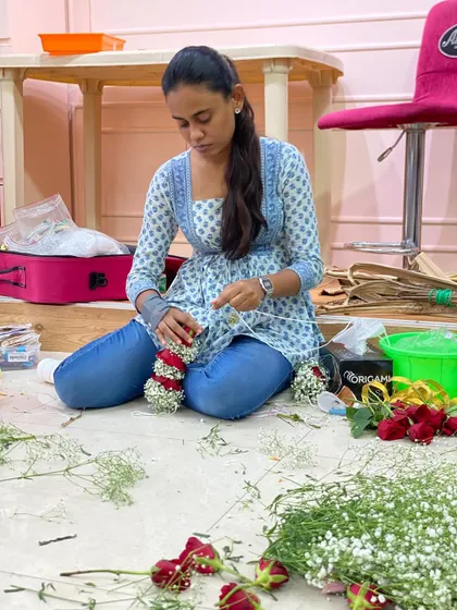 A trainer demonstrating the art of traditional flower garland making, a skill that adds immense value to a bridal package.