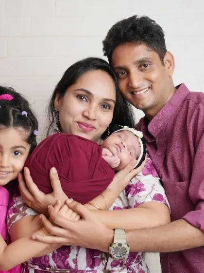 A heartwarming portrait of a family of four, with the parents and older sister lovingly holding the new baby. This photo beautifully captures the beginning of a new chapter for the family.