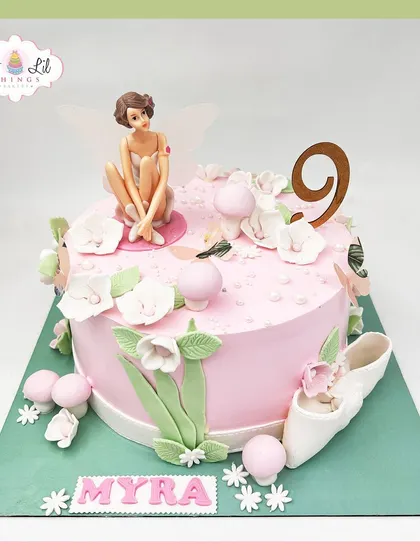 A whimsical fairy cake for Myra's 9th birthday, featuring a delicate fairy, ballet slippers, and soft floral details.