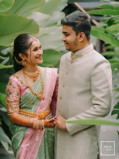 A candid moment of shared smiles between the couple, surrounded by lush greenery. This image captures the natural and easy love they share.