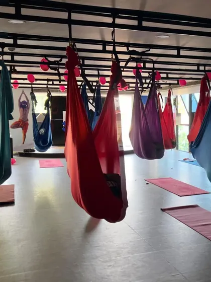 The aerial yoga studio set up and ready for class, with colorful silks hanging.
