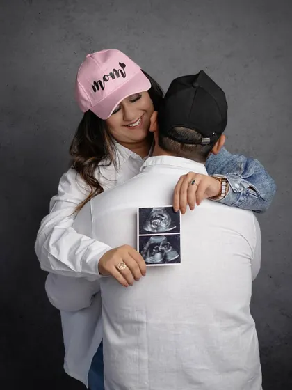 A cute and modern announcement using "Mom" and "Dad" caps and the first photos of their baby.