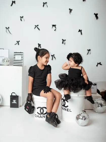 A sweet, interactive moment between the sisters during their fashion shoot. It's a mix of high style and genuine sibling love.