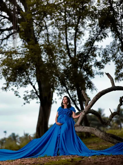 A wide shot showing the impressive length of the sky blue tail gown. This dress is perfect for creating epic, sweeping shots during your outdoor maternity photoshoot.