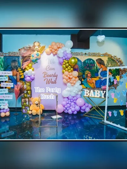 A full view of a "We Can Bearly Wait" baby shower setup. The decor includes a beautiful balloon arrangement, a photo frame for guests, and other interactive elements.