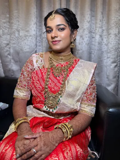 A smiling portrait of Mridhu. The makeup is fresh and radiant, perfect for a traditional wedding ceremony. Her happiness is the best testimonial.