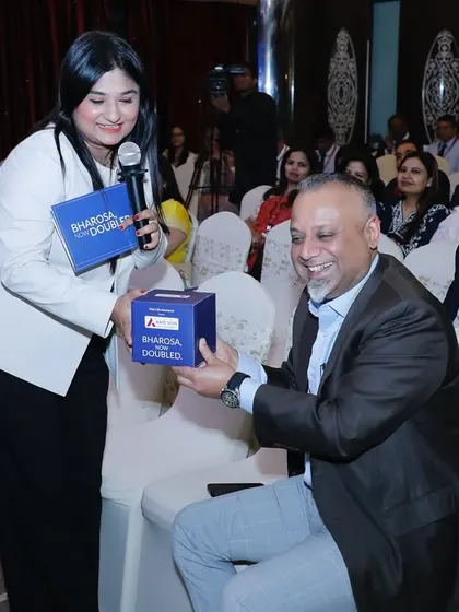 Engaging with a guest during a giveaway segment at the Axis Max Life event.