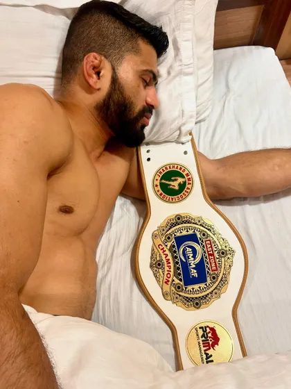 The peace that comes after the battle is won. A champion resting with his title belt after a hard-fought victory.