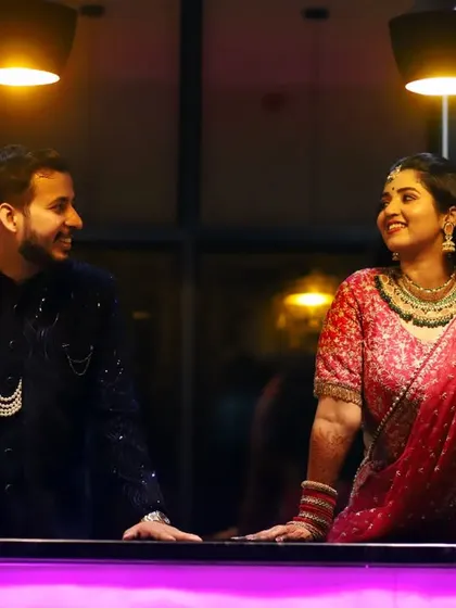 A candid shot of the couple sharing a happy moment during their ring ceremony. The ambient lighting and their expressions create a warm and intimate atmosphere.