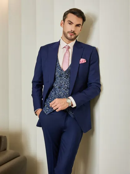 Embracing classic sophistication in timeless silhouettes and master craftsmanship. This angle shows the sharp cut of the jacket and the intricate pattern of the waistcoat, a combination designed for men who appreciate true sartorial style.
