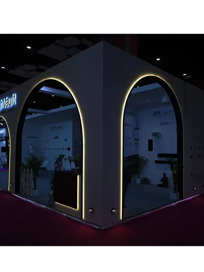 Our exhibition booth illuminated at night. The architectural arches and integrated lighting were designed to create a welcoming and high-tech entrance, inviting visitors to explore the world of TechVault.