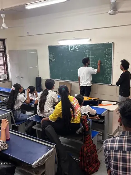 Students and fellows collaborate at the blackboard during a music theory lesson. We make learning the fundamentals of music an interactive and engaging group activity.