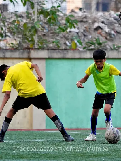 A player in a green bib tries to outmaneuver a defender. I use bibs to create different team scenarios and tactical challenges.