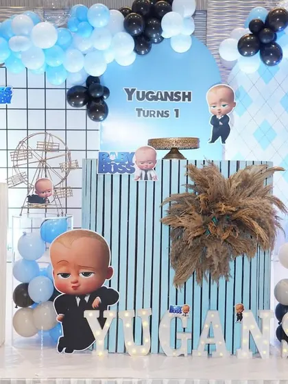 The cake table area for the Boss Baby theme is full of details. The pedestals are decorated to match the theme, and small character cutouts are placed throughout the setup.