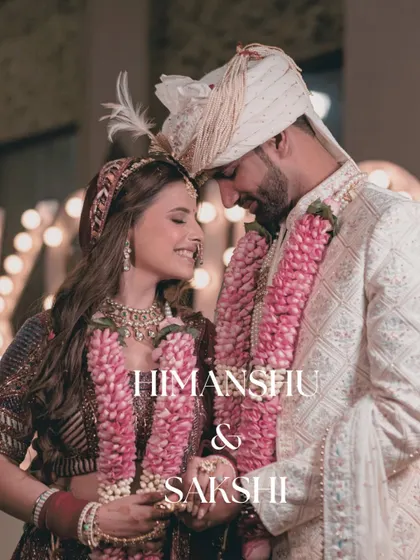 An intimate and romantic close-up of the couple, their garlands symbolizing their union. The soft focus creates a dreamy, fairytale-like feel.