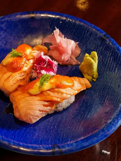 A feast for your senses. This plate of torched salmon nigiri is a work of art, with bold flavors and a beautiful presentation that promises culinary perfection.