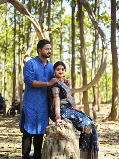 A posed portrait in the forest, with the couple framed by the natural lines of the trees. This shot combines traditional portraiture with a beautiful outdoor setting.