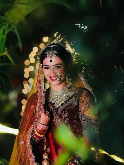 A candid, happy moment captured through the foliage. This photo shows the bride's radiant smile, a key part of any bridal look I create.
