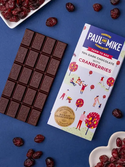 A 70% dark chocolate with cranberries bar, with the ingredients scattered around to visually communicate the flavor.