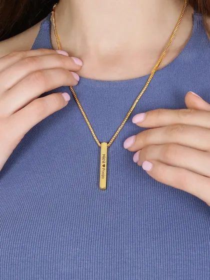 A close up shot of a personalized bar necklace being worn. This image clearly shows the product in a real life context, highlighting the engraving detail and making it a perfect shot for a product page.