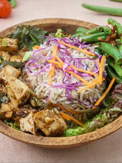 Our Asian Tofu Bowl is a perfect example of a balanced and flavorful meal. It combines protein from the savory tofu, complex carbs from the rice, and plenty of vitamins from the crisp chili garlic green beans and shredded vegetables.