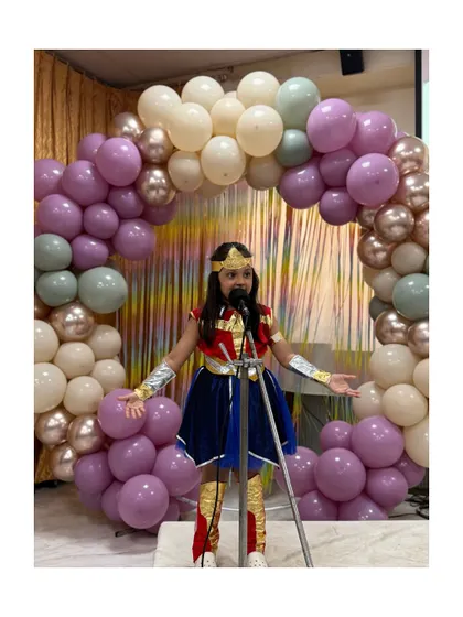 Wonder Woman addresses the audience, a perfect example of how costumes help children step into character and perform fearlessly.