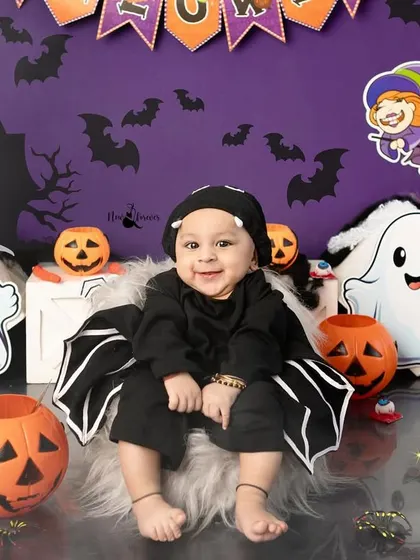 Another adorable shot of our little bat, with a cauldron prop adding a touch of magic to the Halloween scene.