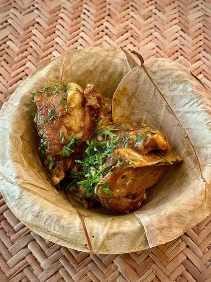 A close-up of a hearty mutton dish served in a leaf bowl. The focus is on the rich, home-style gravy and tender meat, a hallmark of my cooking.