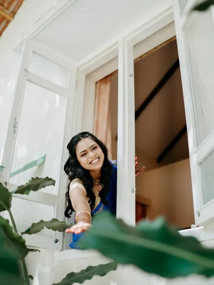 A bride's playful and happy moment, reaching out from a window to a friend below.