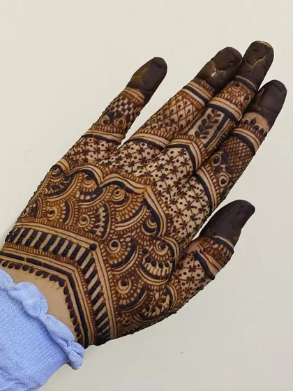 This back-of-hand design features a beautiful scalloped border and a mix of jaali (net) and floral patterns on the fingers.