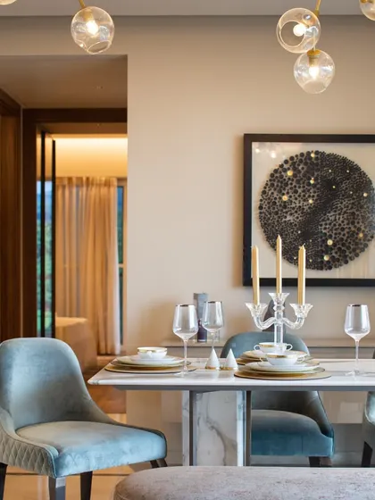 A modern dining room with plush velvet chairs and a striking bubble chandelier, showcasing a sophisticated and contemporary aesthetic.