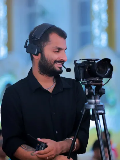 A candid photo of me at work during an event, smiling while operating my camera. This shows the passion and enjoyment I find in my craft.