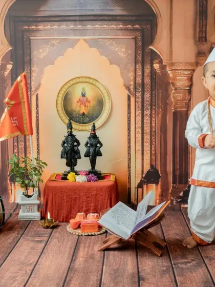 A full-body standing shot that captures the baby's confident posture in his traditional attire.