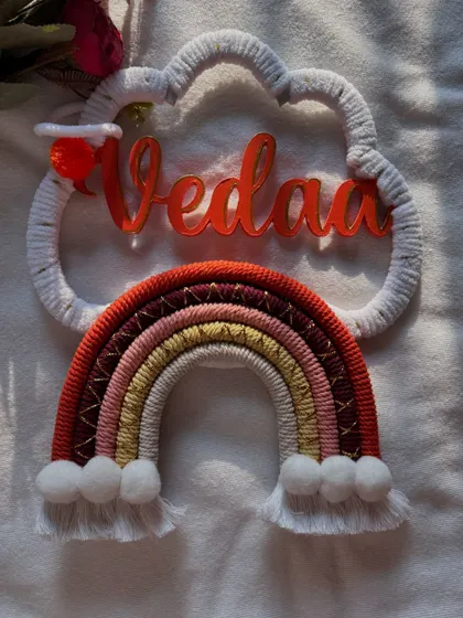 The 'Vedaa' name hanging without the lights on, showing the beautiful craftsmanship and color details in natural light.