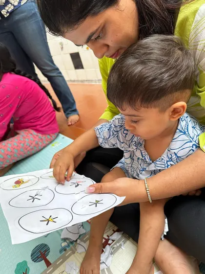 A parent and child work together on a fine motor activity. These shared moments in my classes help build a strong foundation for learning.