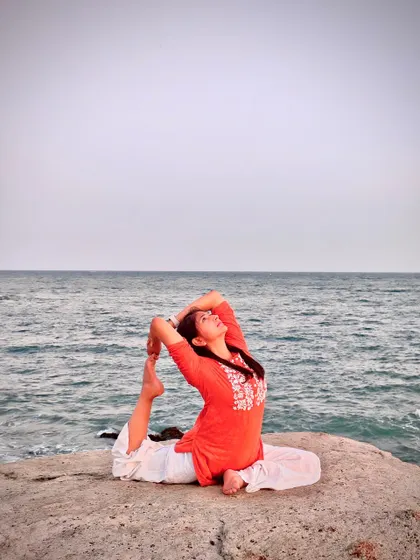 A serene photo of Eka Pada Rajakapotasana (One-Legged King Pigeon Pose) by the sea. Yoga begins with listening. When we listen, we give space to what is.