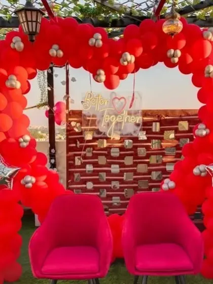 I created this bold, heart-shaped balloon arch entirely from red balloons for a romantic celebration. The 'Better Together' sign and two comfortable pink chairs make it a perfect seating area for the couple of the hour.