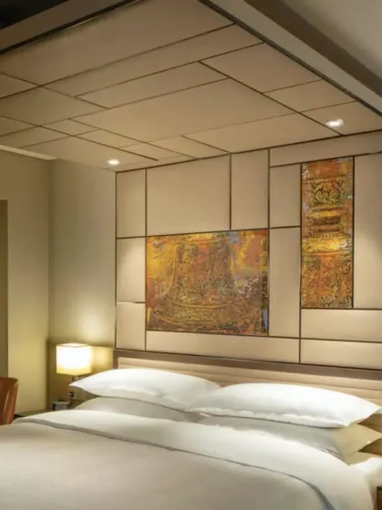 A masterfully integrated artwork above the headboard in a Master Room at the Sheraton Grand. This piece subtly incorporates architectural elements from Karnataka's heritage, including the Mysore Palace and Badami pillars.