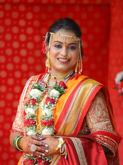 A classic bridal portrait. Her makeup is elegant and timeless, enhancing her natural beauty and complementing her traditional Maharashtrian attire.