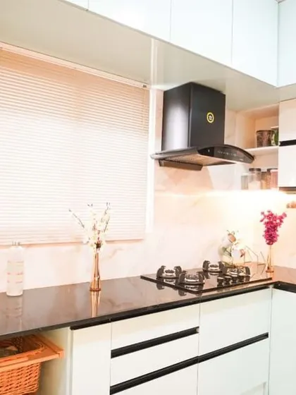 A complete view of this modern kitchen, highlighting the smart use of space with a rolling shutter unit for appliances. The combination of white and black creates a timeless, high-contrast look that is both stylish and practical.