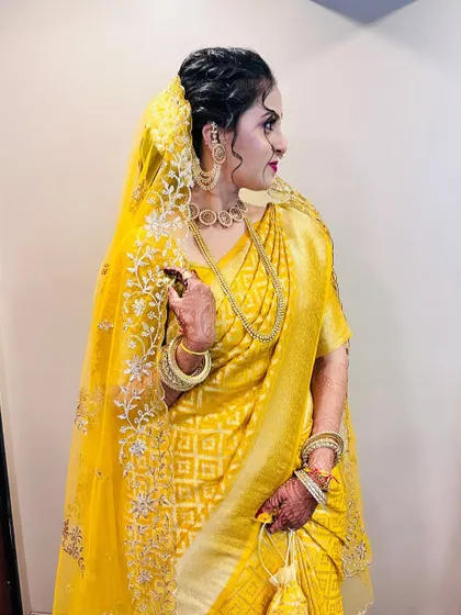 A side profile of the bride, showing her messy bun hairstyle and the beautiful sheer dupatta.