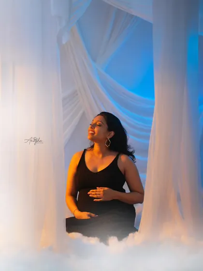 A dreamy and ethereal portrait using flowing white fabrics and a fog machine. The warm and cool lighting creates a magical, heavenly atmosphere.