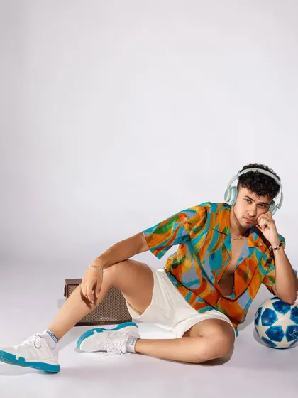 A vibrant, tropical-themed shoot for a men's summer collection. I paired a colorful printed shirt with white shorts and casual accessories like headphones and a speaker to create a fun, youthful, and energetic vibe.