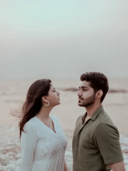 A classic, intimate portrait of a couple against the sea, with the wind adding natural movement.