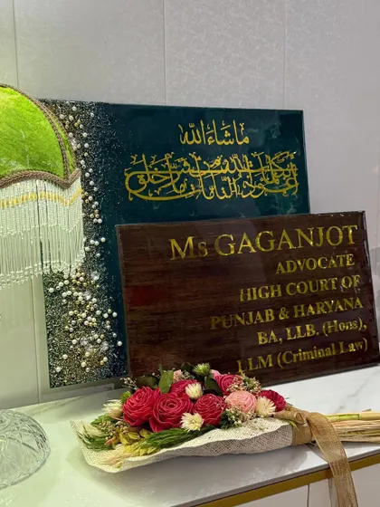 The two plaques for the advocate's office, displayed together with a bouquet of flowers, showing how they can complement a professional space.