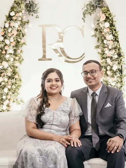 A classic and elegant engagement photo backdrop. The couple's monogram is framed by two beautiful arches of pastel roses, creating a timeless and romantic setting.