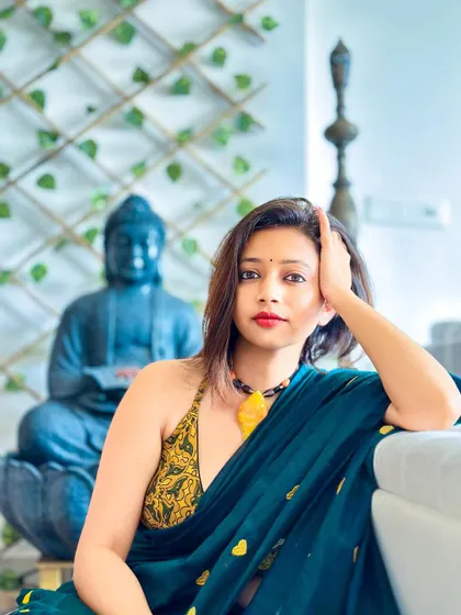 A close-up portrait in the green heart saree. The halter neck blouse adds a modern, sultry touch to the traditional fabric.