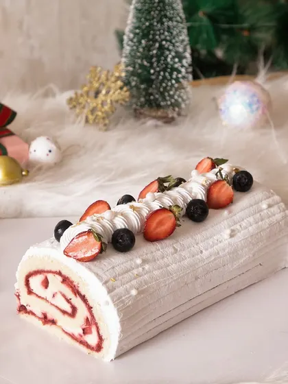 Another view of the festive strawberry swirl log cake, perfect for a white Christmas theme.