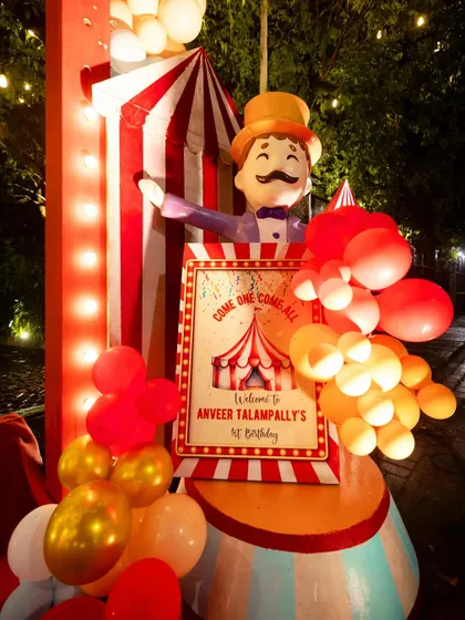 A "Come One, Come All" welcome sign for a carnival-themed first birthday. The sign is part of a larger prop featuring a ringmaster, creating a grand and inviting entrance.