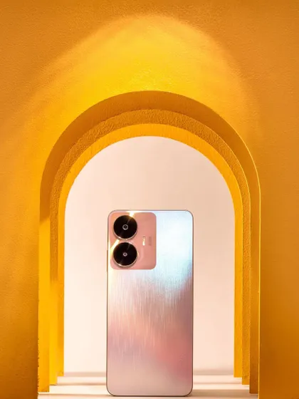 The Realme C55 phone framed by yellow paper arches. This creative setup uses color and depth to make the product pop, perfect for an ad campaign.